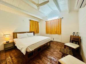 帕罗林Cocos Beach Resort的一间卧室设有一张大床和一个窗户。