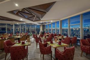 苏莱曼尼亚Titanic Hotel & SPA的餐厅设有桌椅和窗户。
