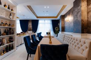 拉姆尼库沃尔恰Hotel NOBLESSE Boutique&Spa的餐厅设有一张长桌和蓝色椅子
