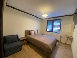 西洛卡卢卡Star Dust的卧室配有床、椅子和窗户。