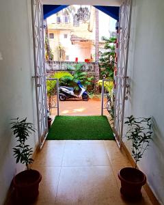 卡兰古特CASA SOMANJO INN的通往一个有两株盆栽植物的院子的敞开的门