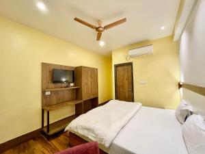 瓦拉纳西Hotel SHIVAM ! Varanasi Forɘigner's-Choice ! fully-Air-Conditioned-hotel, lift-and-Parking-availability near-Kashi-Vishwanath-Temple and-Ganga-ghat的一间卧室配有一张床和一台电视。