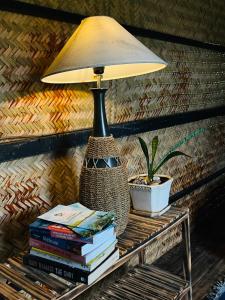 昆岛Con Dao Backpacker - LoCo Camping的坐在桌子上边的台灯,上面有书