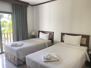 乌隆他尼President Hotel Udonthani的酒店客房,配有两张带毛巾的床