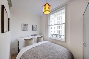 伦敦Stunning Hyde Park Apartment的一间卧室设有一张床和一个窗口