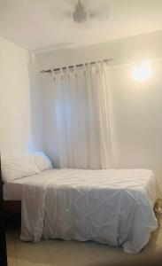 蒙巴萨Moraa’s Home的一间卧室设有两张带白色床单的床和窗户。