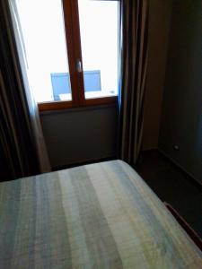 科森扎Uniclub House的卧室在窗户前配有一张床