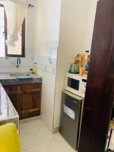 蒙巴萨Moraa’s Home的厨房配有微波炉和冰箱。