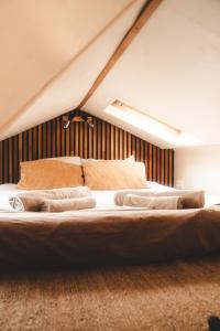 绍蒙－吉斯图Tiny House Au Coeur de la Campagne Wallonne的一张床上有两个枕头的房间