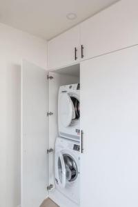 安特卫普Classy flat with awesome view and great location!的一间白色洗衣房,配有2台洗衣机和烘干机