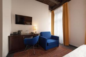 波兹南Palazzo Rosso Old Town的酒店客房配有2把蓝色椅子和书桌