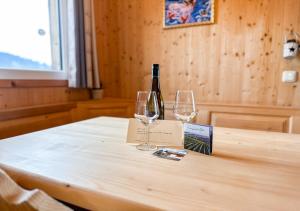 巴特圣莱昂哈德艾1A Chalet Rast - Grillen mit Traumblick, Indoor Sauna的桌子上放有一瓶葡萄酒和两杯酒