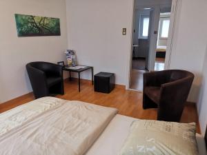苏黎世Turicum Apartment mit Balkon und Parkplatz的一间卧室配有一张床、两把椅子和一张桌子