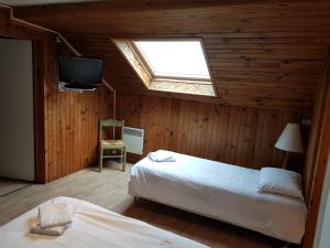 特恩顿麦永瓦喀斯酒店的一间卧室设有两张床、一台电视和天窗。