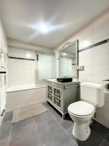 布鲁塞尔Cosy Apartment Brussels - Flagey的浴室配有卫生间、浴缸和水槽。