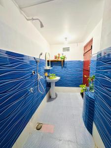 阿鲁甘湾Beach Cab Resort的浴室拥有蓝色的墙壁和水槽