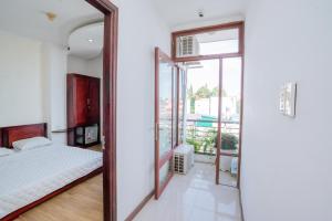 邦美蜀Triệu Vũ Hotel & Apartment的一间卧室配有一张床和一面大镜子