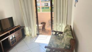 安格拉杜斯雷斯Suite Baia dos Corais的客厅配有电视和椅子