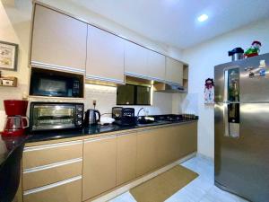 埃斯特城Agradable dormitorio en suite con estacionamiento privado的厨房配有不锈钢冰箱和微波炉。
