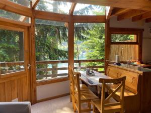 拉安戈斯图拉镇BOG Le Pommier - Cabañas con vista al lago y piscina climatizada的厨房配有桌椅和窗户。