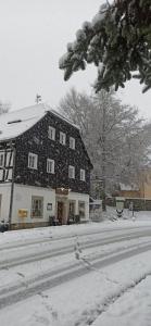 Luftkurort LückendorfGasthof Alte Schmiede G*** Lückendorf的一座房子被雪覆盖在院子里