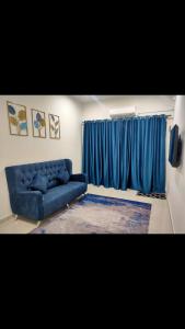 安顺Homestay Fayyadh Teluk Intan 3Room2Bath的客厅设有蓝色的沙发和窗户。