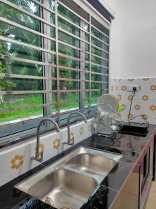 安顺Homestay Fayyadh Teluk Intan 3Room2Bath的厨房设有水槽和窗户。