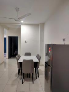 安顺Homestay Fayyadh Teluk Intan 3Room2Bath的一间带桌椅和冰箱的用餐室