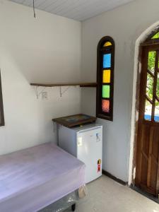 卡马萨里Cantinho dos Machados的一间小型客房,配有冰箱和窗户。
