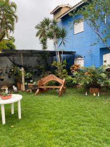 卡马萨里Cantinho dos Machados的一个带桌子和蓝色房子的花园