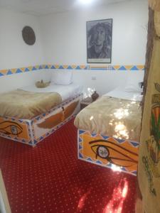 卢克索peace garden hostel & camp的红地毯间内的两张床