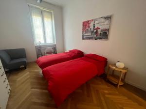 米兰Porta Venezia Apartament的红色床单的客房内的两张床