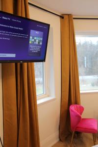 贝尔维尔4 Guest Suite with Waterfront Views at Fancie's PEC的窗户和红色椅子的房间的电视