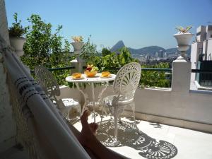 里约热内卢比安卡旅馆的躺在带桌椅的阳台的人