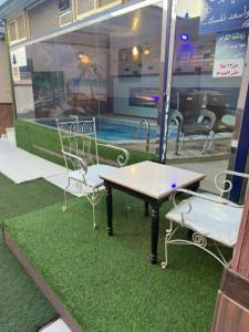 艾卜哈Roof chalets Roof chalets的一张桌子和两把椅子坐在游泳池旁