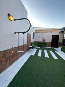 艾卜哈Roof chalets Roof chalets的一间铺有绿色地毯的客房和一座建筑