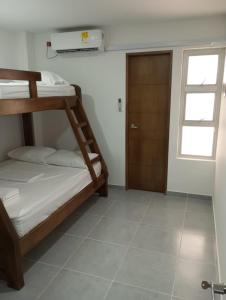 科韦尼亚斯Apartamento Villa Mary-Coveñas的一间卧室设有两张双层床和一扇门