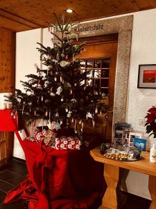马洛亚Maloja Kulm Hotel的房间里的圣诞树和礼物