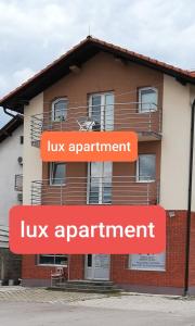 巴尼亚卢卡LUX APARTMENT的前面有两个橙色标志的建筑