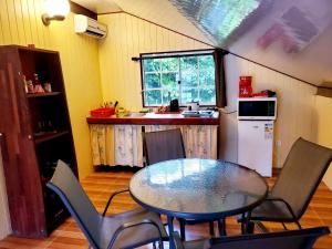 乌图罗阿Studio Rava 1 Room Fare Tepua Lodge的一间带桌椅的厨房和一间带冰箱的厨房