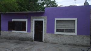 特尔马斯德里奥翁多La casa de valle的紫色的房子,设有门和两扇窗户
