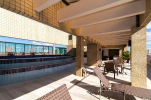 巴西利亚Apartamento em hotel 5 Estrelas Brasília - GMB0414的一座带椅子的庭院和一座位于大楼内的游泳池