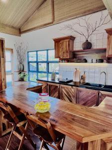 富国TỊNH House Phú Quốc的一个带木桌和椅子的大厨房