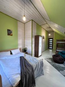 沃罗赫塔ЛемГора的一间设有一张大床的卧室,位于带绿色墙壁的房间
