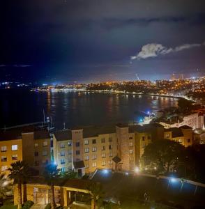 康康Precioso depto vista al mar Concon Condominio Tipo Resort 2 dormitorios的夜晚的城市景观与水体