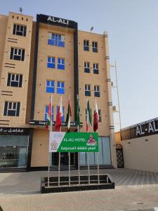 哈费尔巴廷العلي للشقق المخدومة Alalihotel的建筑物前的一组旗帜
