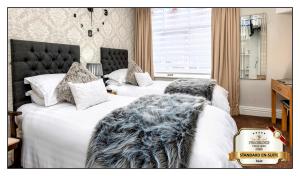布莱克浦Pembroke Bed & Breakfast的配有白色床单的酒店客房内的两张床