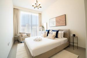 迪拜Veluxa - Luxe 2Bed in Downtown!的卧室配有一张白色大床和一把椅子
