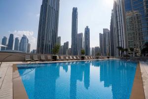 迪拜Veluxa - Luxe 2Bed in Downtown!的一座位于城市的游泳池,有高大的建筑