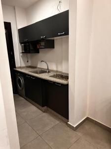 安曼Gentle Breeze Studio1的厨房配有水槽和洗衣机